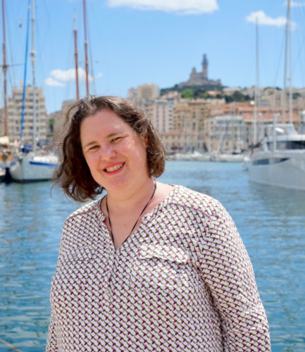Votre guide touristique Caroline derrière le ferry-boat et Notre-Dame de la Garde