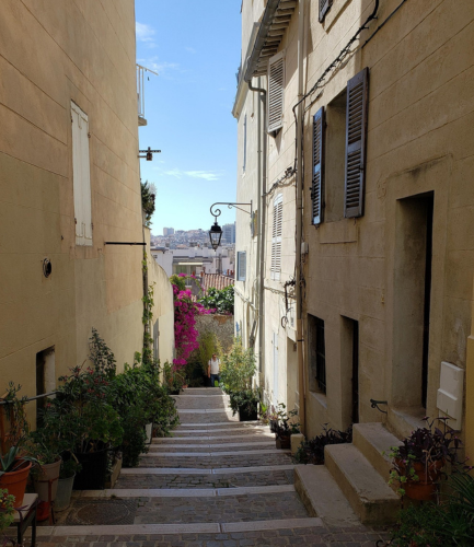 petite rue du Panier avec des plantations et des escaliers, au loin la ville